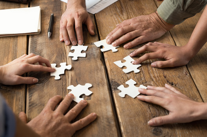 Closeup of businessman and woman with jigsaw puzzle pieces in office